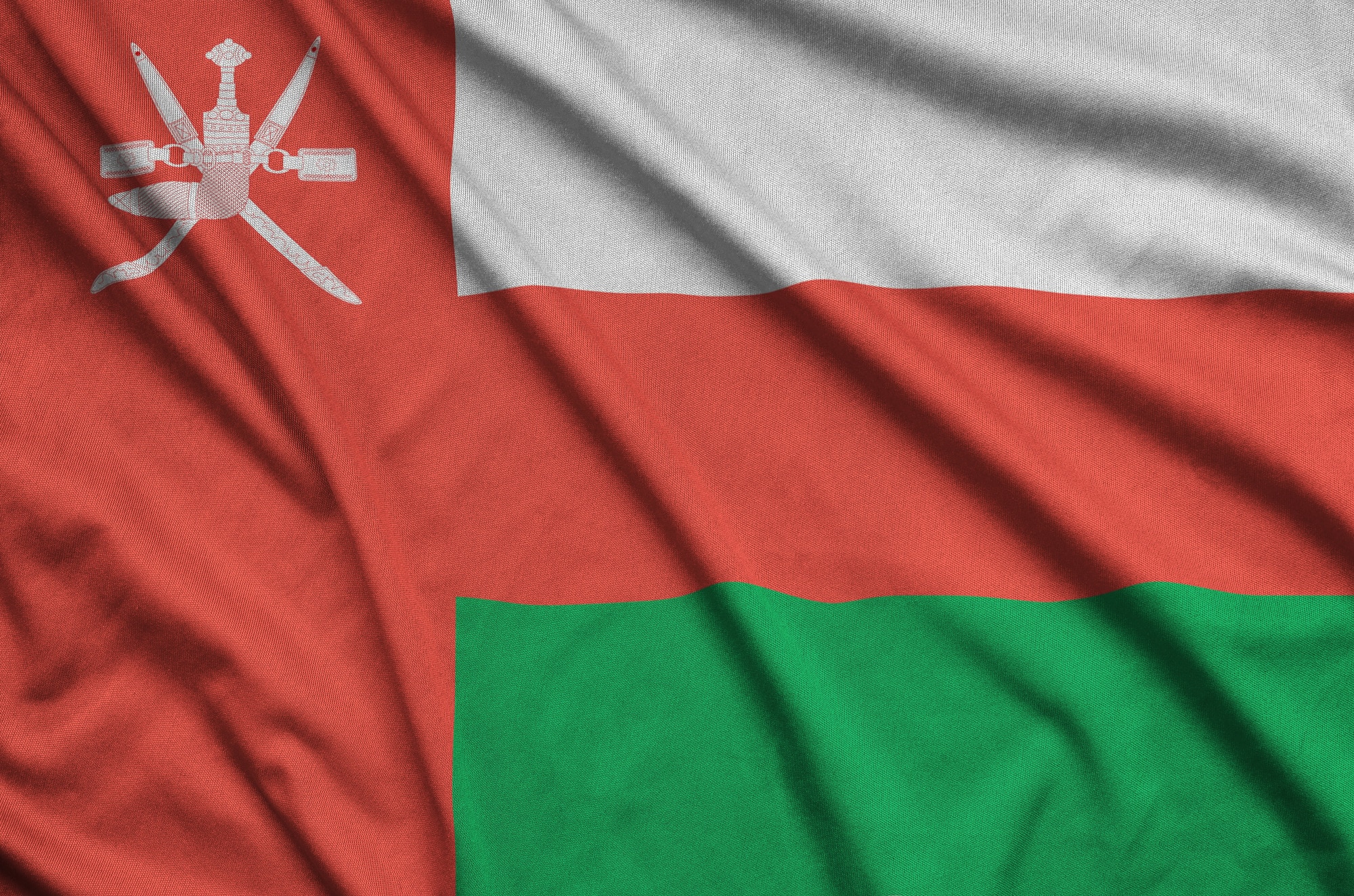 من نحن 9 Oman flag is depicted on a sports cloth fabric with many folds. Sport team waving banner