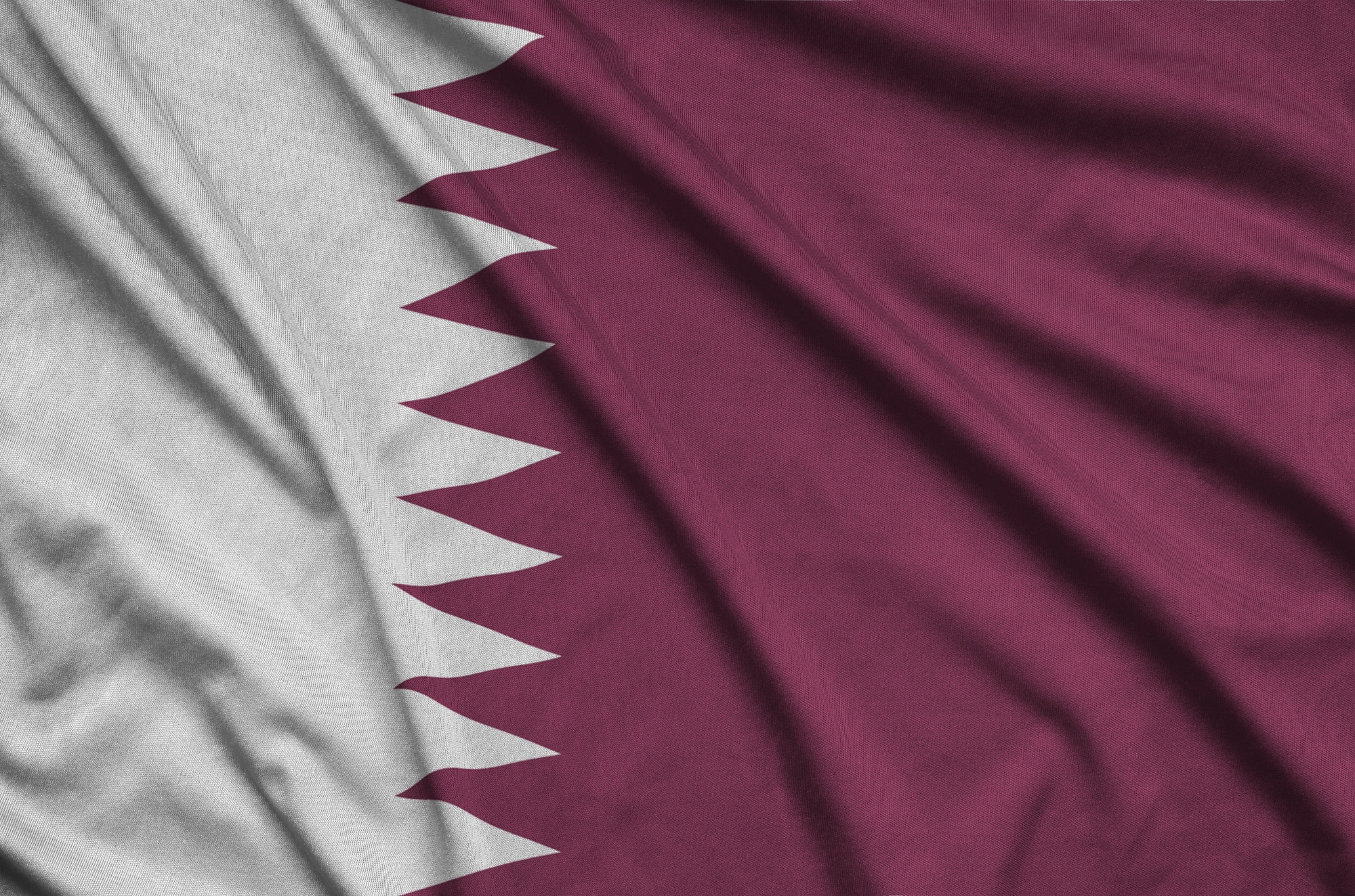 من نحن 10 Qatar flag is depicted on a sports cloth fabric with many folds. Sport team waving banner