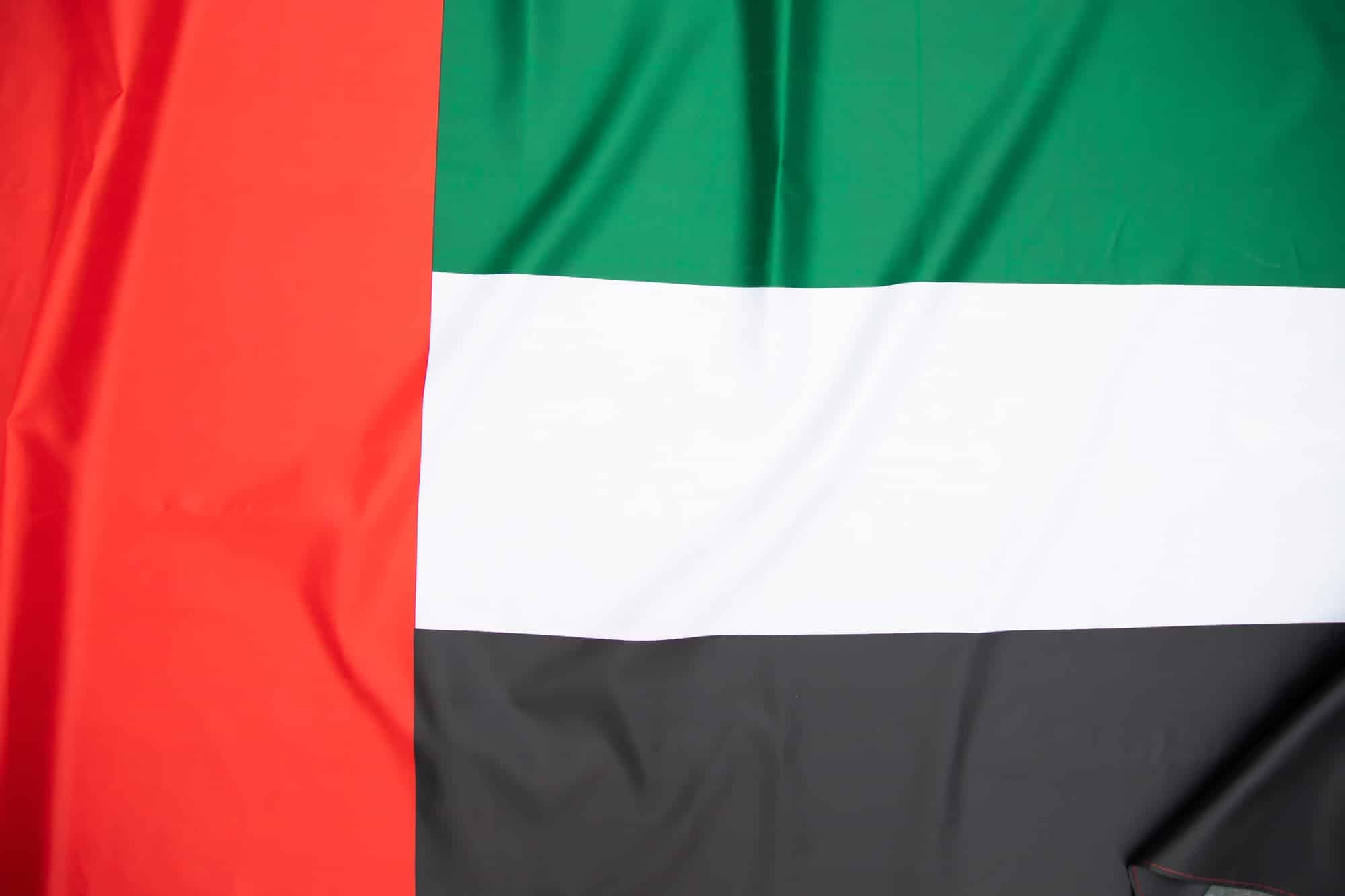 من نحن 7 United Arab Emirates flag blowing in the wind. Background texture.
