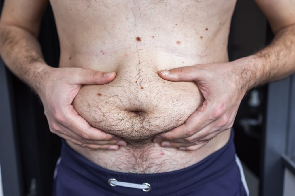 الصيام المتقطع - دليل شامل بكل ما تحتاج معرفته 2 Man holding stomach fat